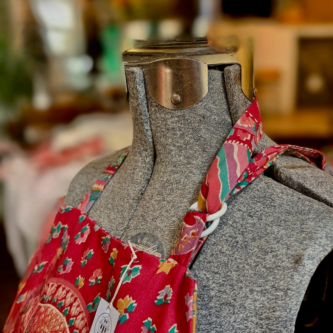 Close-up of the closure mechanism of a colourful paisley and geometric apron on a mannequin