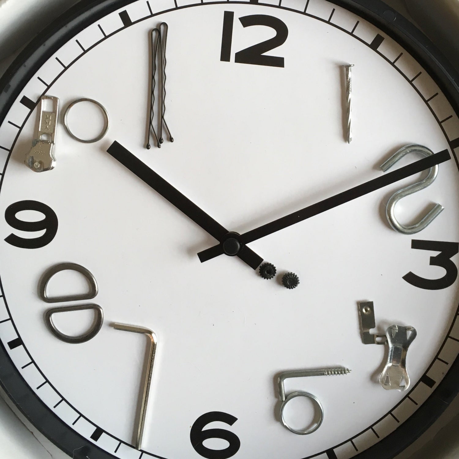Close-up of a clock face with decorative hour markers made from found and salvaged materials