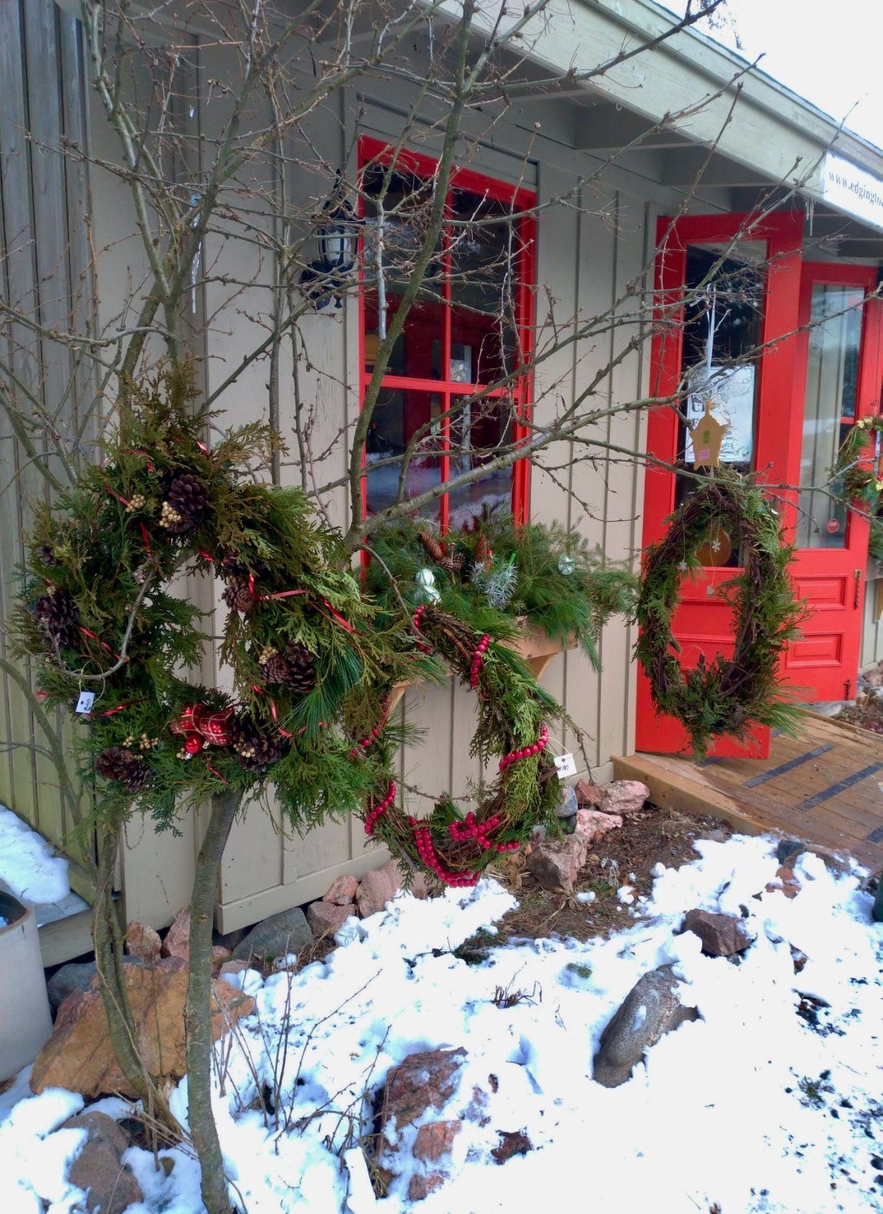 handmade pine and spruce wreathes hanging outside the shop in winter  