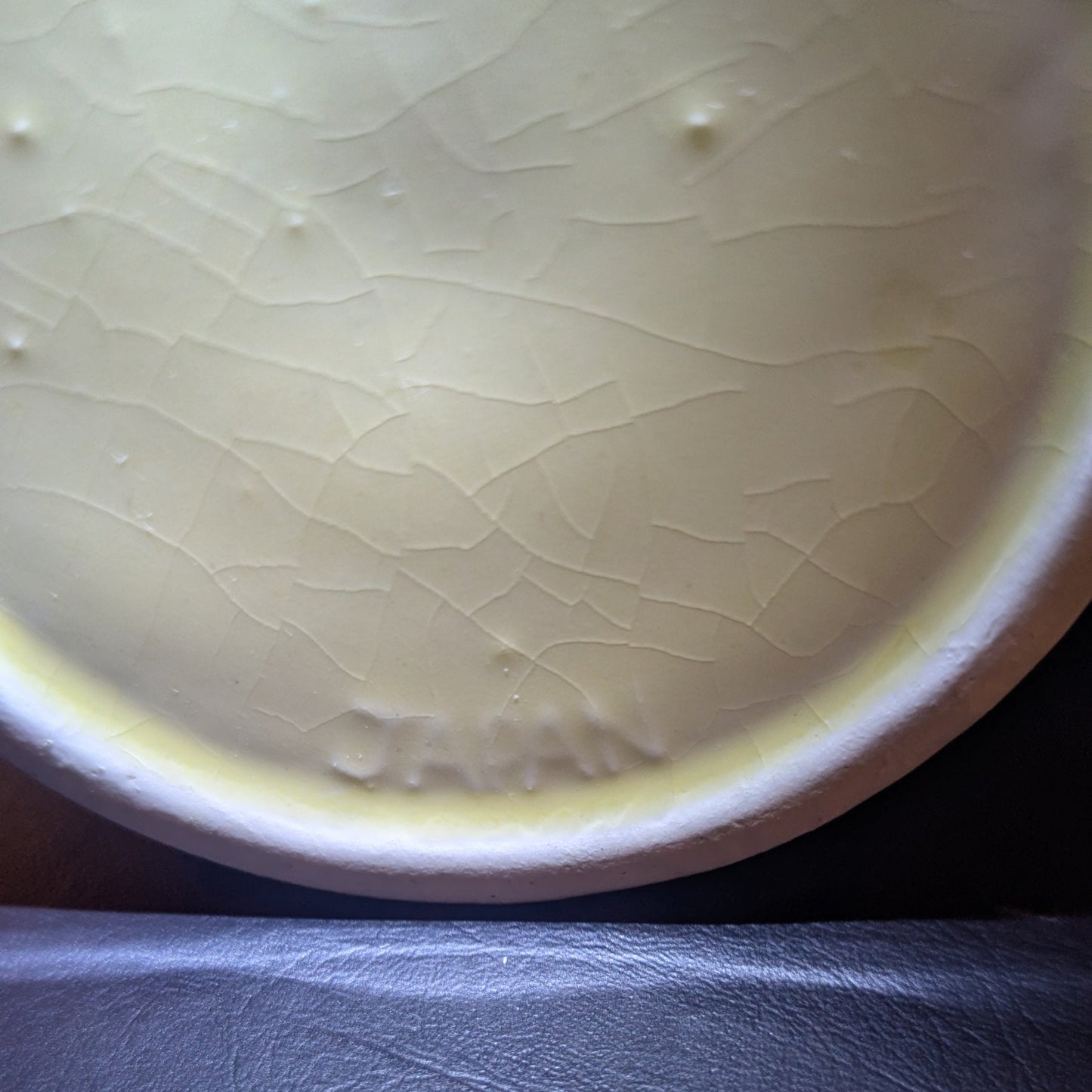 The base of a yellow teapot showing the mark 'JAPAN'