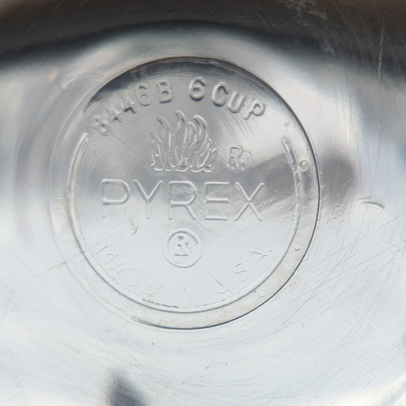 Close-up of a glass Pyrex teapot base showing Pyrex mark, size, and model number