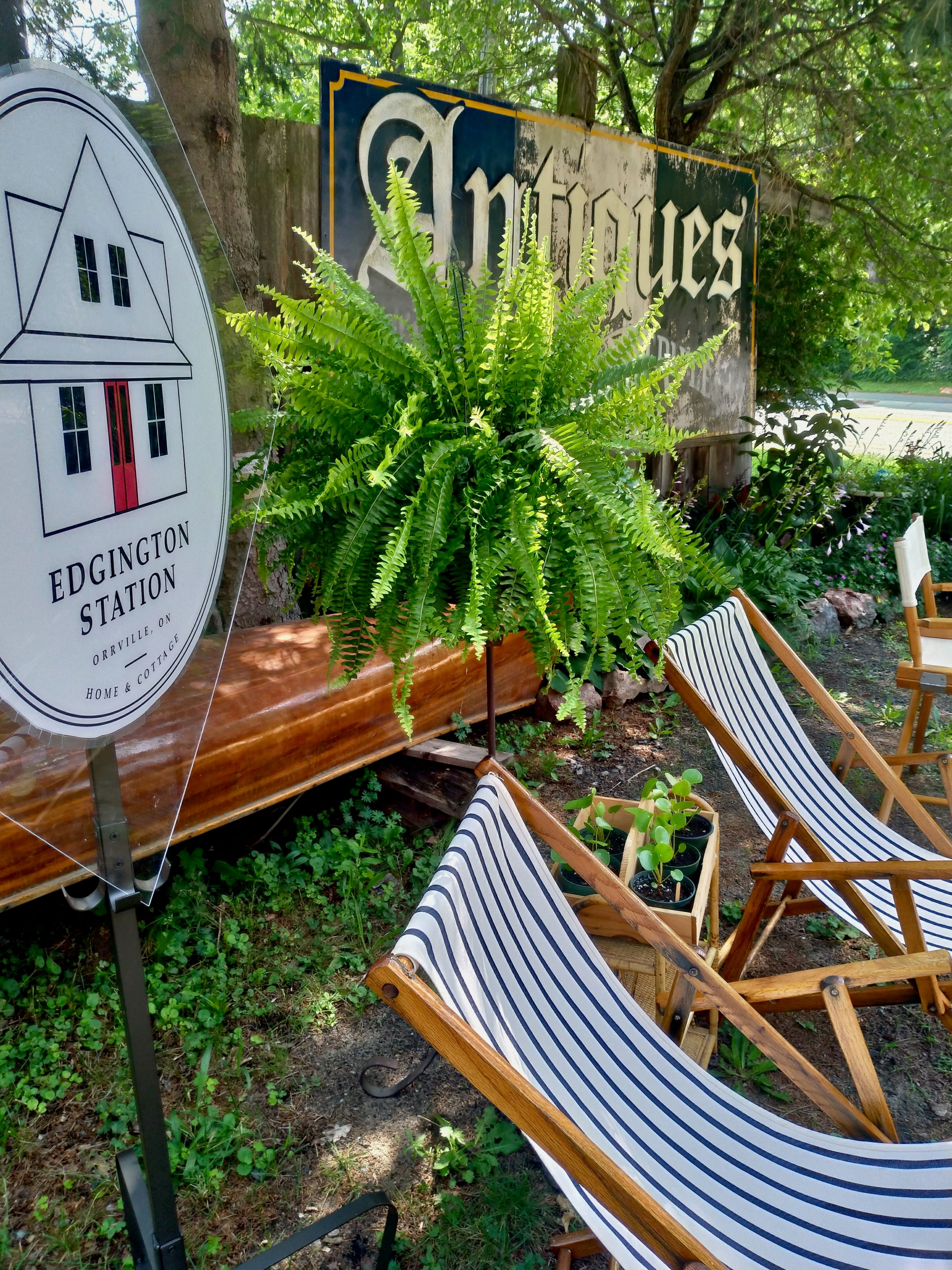 2 vintage beach chairs with new covers sit next to an old canoe